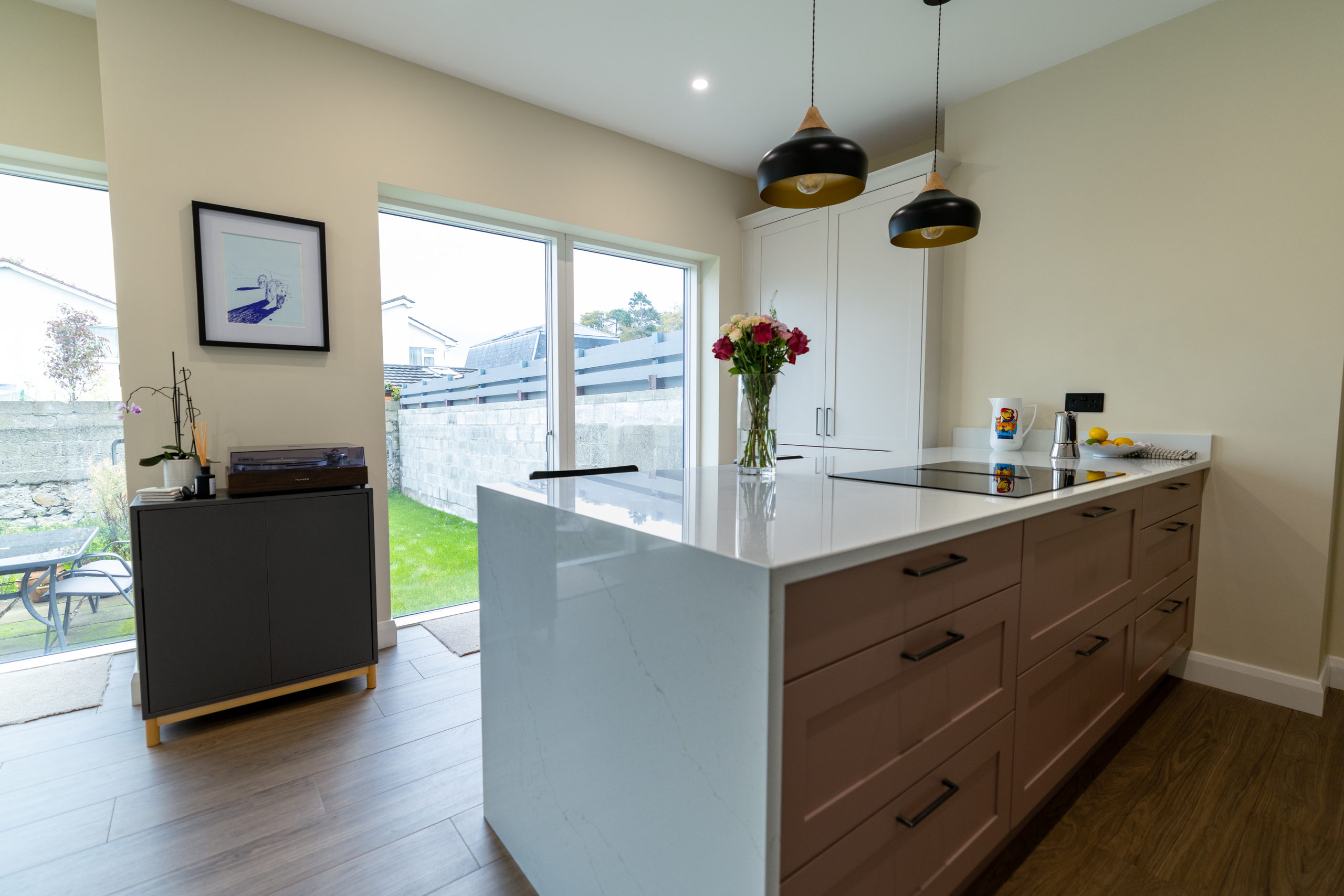 Open-plan kitchen and dining space with island and garden doors in a renovated 1950s Blackrock dormer bungalow