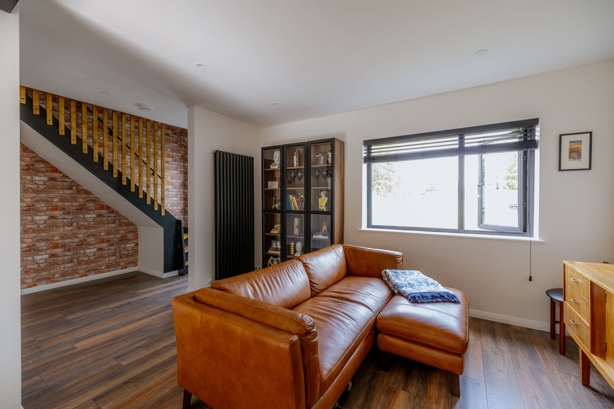Open-plan living room with exposed brick and timber flooring in a renovated 1970s Lucan mid-terrace home